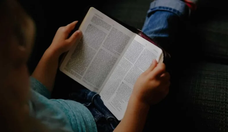 Niño leyendo un libro sagrado acerca de que es la verdad
