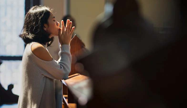 LOGOS 9 11 Mujer orando en un banco de iglesia. 1 Juan 3:9